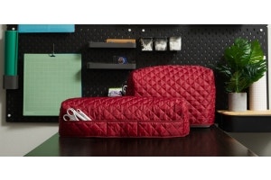 A sewing machine and a Cricut with red Covermates Keepsakes covers