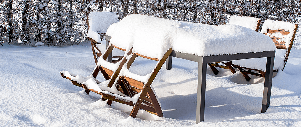 Outdoor table and chairs covered in snow