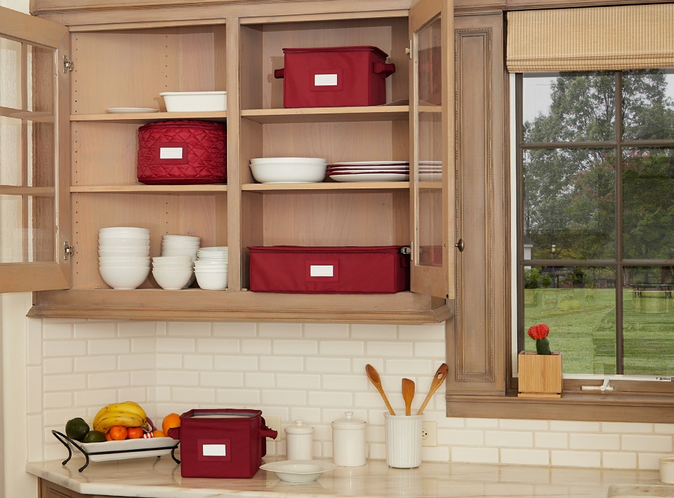 Red dish storage boxes inside a clean kitchen cabinet