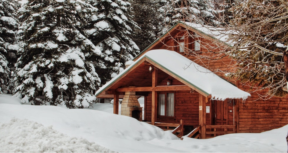 Cabin covered with snow in a forest