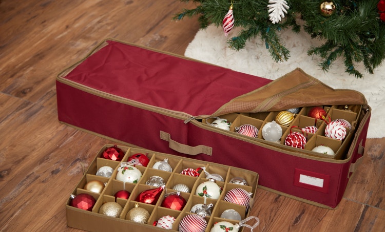 Red underbed ornament storage box in front of a Christmas tree