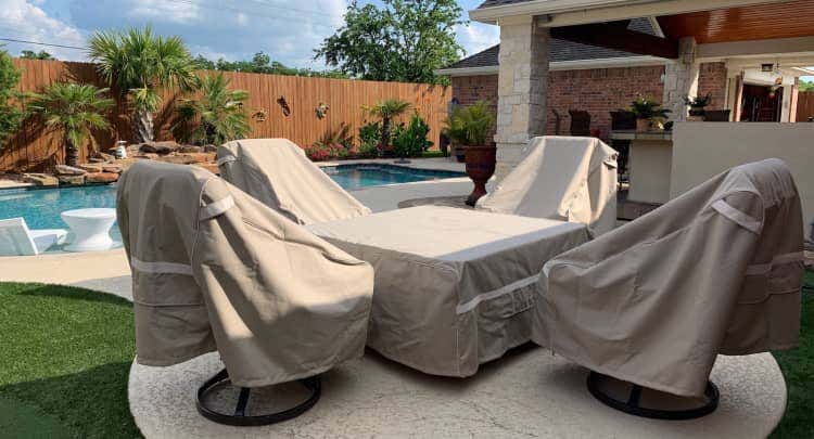 Table and chairs with Prestige covers in a backyard by a pool