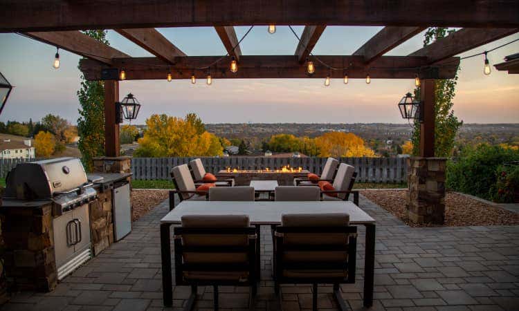 Backyard patio with an island grill, dining table, and fire pit