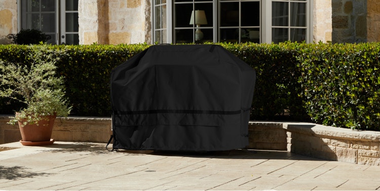 Barbecue grill covered with a black Coverstore grill cover