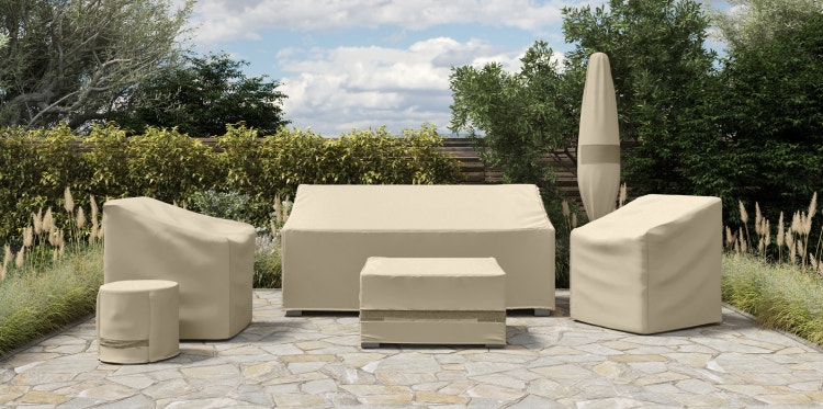 Outdoor sofa, two outdoor chairs, two accent tables, and an outdoor umbrella all covered in Coverstore's Elite collection of patio furniture covers