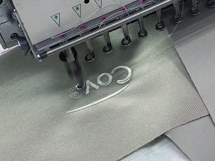 Covermates logo being sewn to a cover.