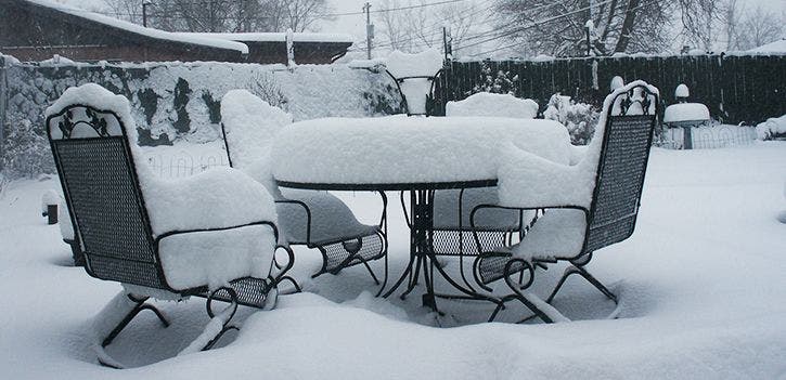 Patio furniture set covered with a thick blanket of snow